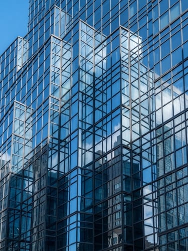 Sharp architectural photography of a modern glass skyscraper facade reflecting crisp blue sky, cool glass-blue tones, high-contrast daylight, 50mm.