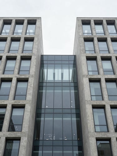 Symmetrical perspective of a modern concrete and glass corporate building facade, clean lines, cool overcast daylight, minimalist architectural geometry.