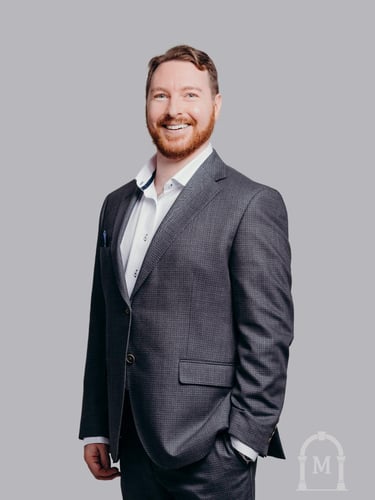 Photo of Dustin Morris the Owner of Morris Household. He is wearing a dark grey suit and white shirt