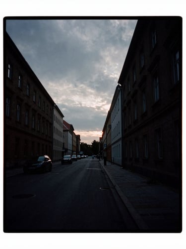 Moody cinematic film photography of a dark Berlin street under overcast sky, high contrast shadows, anamorphic lens, 35mm grain