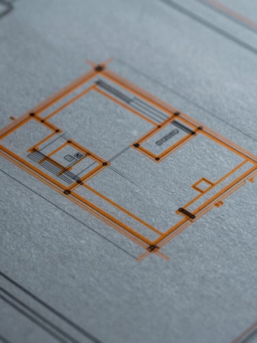 Macro shot of architectural blueprint with digital orange overlay, sharp focus, clean technical lines, cool daylight.