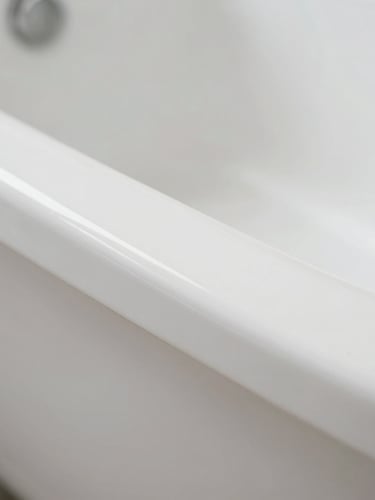 Sharp macro photography of a pristine white porcelain bathtub edge, focused cool-toned work light highlighting a flawless smooth surface transition, 35mm
