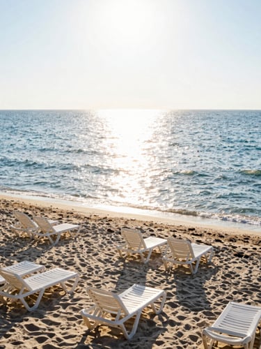 Wide environmental shot of a clean Romanian beach at sunrise, golden light reflecting on the calm Black Sea waves, empty sunbeds, high-key natural lighting