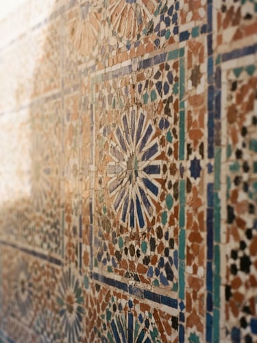 Detailed close-up of sun-drenched zellij tilework in a quiet riad courtyard, warm terracotta and sand tones, soft morning light, shallow depth of field