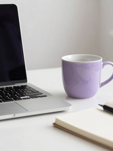 Bright editorial photo of a clean modern workspace with a high-end laptop, notebook, and a soft violet ceramic cup, illuminated by soft natural daylight, minimalist background.