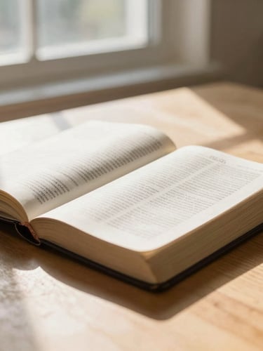 A close-up shot of an open Bible on a light oak table, soft morning daylight streaming through a window, warm tones, shallow depth of field, editorial photography