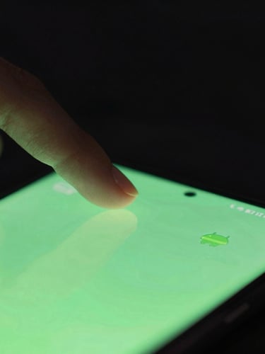 Macro close-up of a hand interacting with a clean, dark-mode Android interface, vibrant neon green accents, soft screen glow, moody low-key lighting.