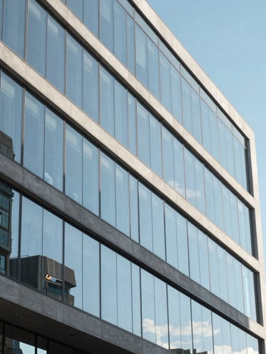 Close-up architectural shot of a modern glass office building facade reflecting the clear blue sky in Vitacura, bright daylight, clean lines, sharp focus, 35mm
