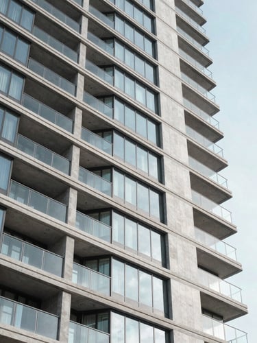 Low-angle architectural photography of a modern luxury residential high-rise with clean glass and concrete facades in Las Condes, bright crisp morning daylight, cool desaturated tones, sharp focus, 35mm