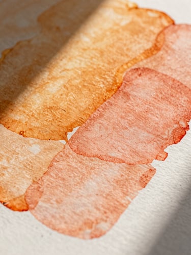 Extreme close-up of a tactile print mockup with visible heavy paper texture, warm sunlight casting sharp diagonal shadows across vibrant amber and soft coral ink layers.