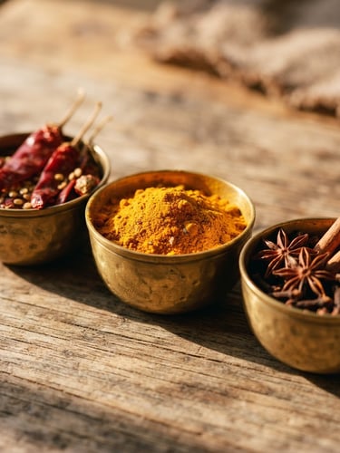 Macro close-up of vibrant raw spices in brass bowls under warm directional morning sunlight casting soft shadows, 35mm photography