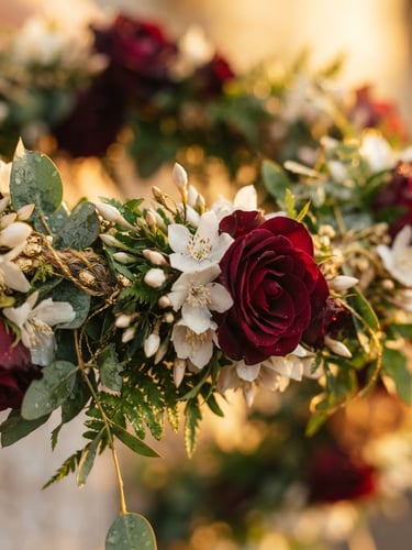Intimate macro shot of fresh-cut jasmine and roses woven into a luxurious wedding garland, warm golden-hour lighting, shallow depth of field, 35mm