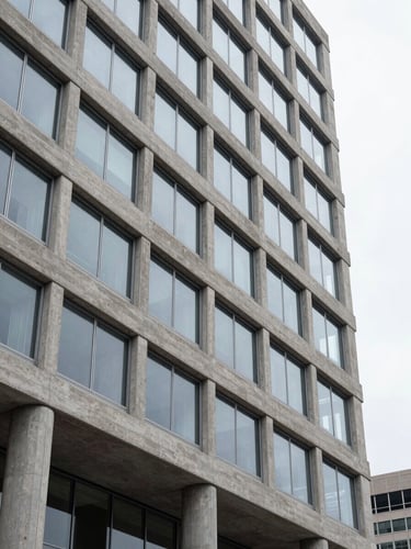 Architectural close-up of a modern concrete and steel corporate headquarters in Denver, overcast diffused daylight, frosted clean tones.
