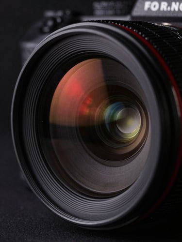 Extreme close-up of a high-end camera lens reflecting a sharp red light, deep shadows, cinematic documentary style, dark background