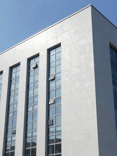 Low-angle architectural shot of a massive, modern industrial facility with clean lines, cool-toned daylight filtering through high windows, sharp focus.