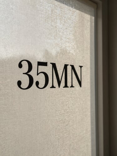 Close-up of textured linen canvas with stark black serif lettering, soft side-lighting from an overcast window, long afternoon shadows, 35mm