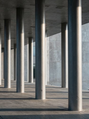 High-contrast architectural detail of modern steel and concrete columns, cool-toned morning daylight, sharp diagonal shadows, wide angle.