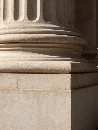 Macro close-up of an elegant limestone column corner, warm natural daylight, deep shadows, architectural stability, 35mm