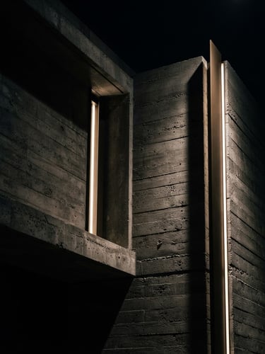 Dramatic low-key architectural detail of a modern luxury concrete building facade, crisp shadows, sharp focus, 35mm lens