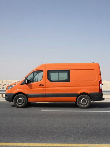 Side profile of a high-visibility orange mobile service van parked on a Bahraini highway shoulder, sharp midday sun casting clean shadows, asphalt and desert horizon in background.