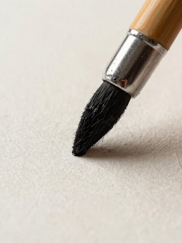 Extreme close-up of a wet bamboo brush tip loaded with black ink touching textured handmade paper, soft natural side-light, macro lens