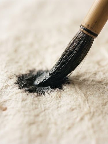 Extreme close-up of a bamboo brush tip loaded with wet black ink touching textured Xuan paper, soft natural side-light.