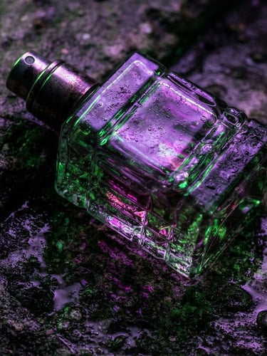 Macro shot of a textured glass perfume bottle, distorted by harsh neon violet and acid green light, casting sharp shadows on a wet concrete surface, Dutch angle, high contrast, raw textures.