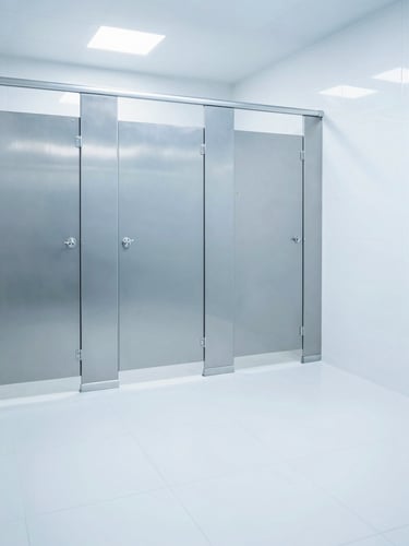 Bright commercial restroom with gleaming stainless steel fixtures and spotless white tile, crisp high-exposure lighting, sterile blue tones