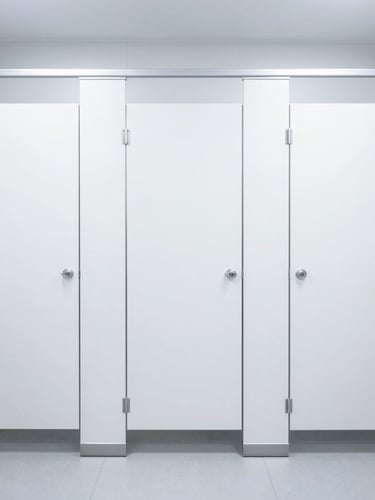Straight-on architectural shot of a gleaming commercial restroom, sterile white and blue tones, bright high-key commercial lighting, sharp focus, 35mm