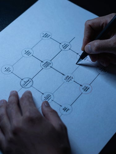 Close-up of hands sketching a high-scale distributed system topology on paper, blueprint-blue ink, low-key focused lighting, technical editorial style.