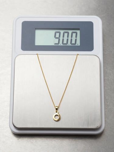 Close-up overhead shot of a certified digital scale displaying a precise gram reading, a gold necklace resting on the weighing platform, clean stainless surface, bright professional studio lighting, no shadows