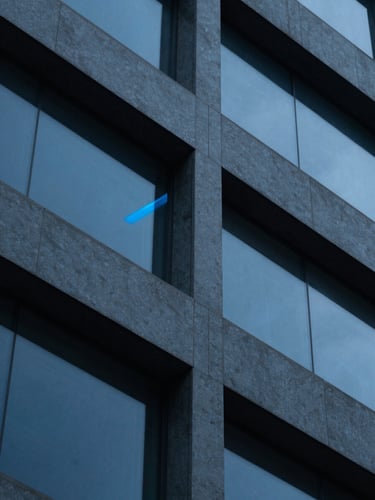 Macro shot of complex geometric architectural lines, sharp glass reflections, cool-toned deep blue and slate gray shadows, crisp directional laser-blue highlight, 35mm editorial photography.