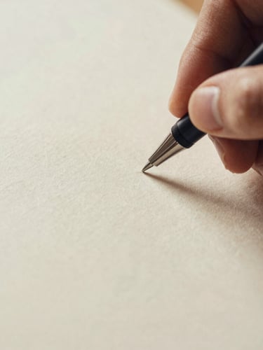 Macro detail of textured paper and a hand holding a pen, shallow depth of field, warm cream tones, high contrast soft shadows, editorial film photography.