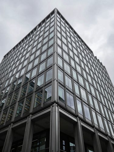 Low angle architectural view of a modern London financial office building, steel and glass grid reflecting overcast grey sky, sharp shadows, technical precision.