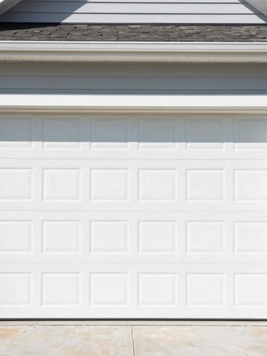 Medium shot of a clean, newly installed modern garage door on a suburban Centerton home, bright natural outdoor daylight, crisp focus.