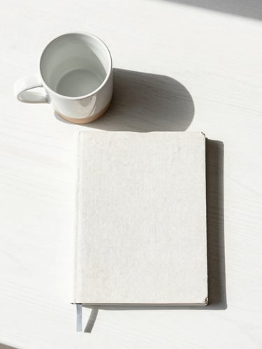 Overhead flat-lay of a heavy ceramic mug and a linen journal arranged with geometric precision on a white oak table, bright natural daylight, soft shadows.