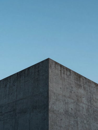 Wide-angle minimalist architectural photography of a modern concrete peak structure against a crisp daylight sky, cool sapphire tones, sharp focus, 35mm