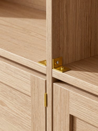 Close-up of precise carpentry joints and brass fittings on a warm oak cabinet, bright natural daylight, crisp architectural details showing construction precision.