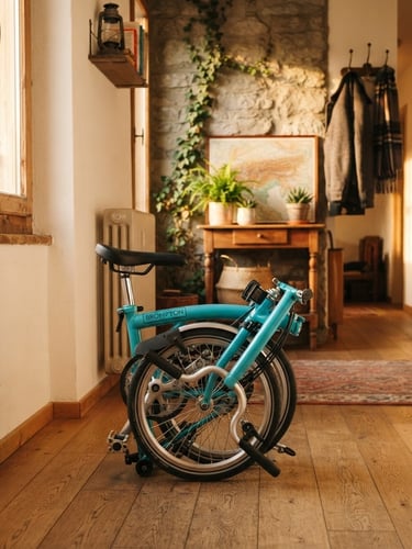 Warm retro lifestyle photography of a colorful folding bicycle folded neatly in a cozy, sunlit Swiss apartment hallway, golden-hour sunlight, 35mm film grain.