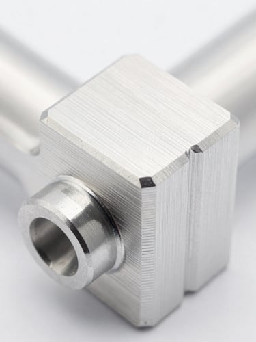 Macro close-up of a pristine CNC machined aluminum component with sharp edges and fine toolpaths, bright high-key studio lighting, shallow depth of field