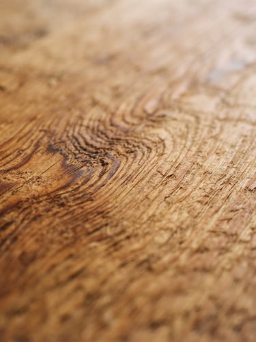 Macro detail shot of a hand-planed Douglas fir timber surface, soft overcast Pacific Northwest window light, rich natural wood grain, shallow depth of field, 35mm