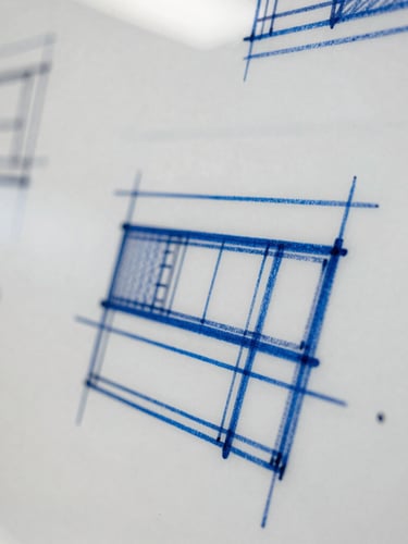 Tight macro shot of complex architectural diagrams sketched on a whiteboard, blue marker lines, shallow depth of field.