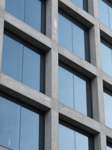 Tight macro detail of modern geometric building facade, concrete and dark blue glass panels, crisp morning daylight, sharp focus