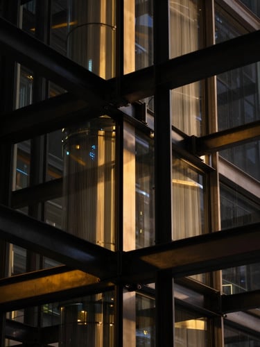 dark editorial tech photography of architectural steel and glass structures with sharp gold light reflections, macro depth of field