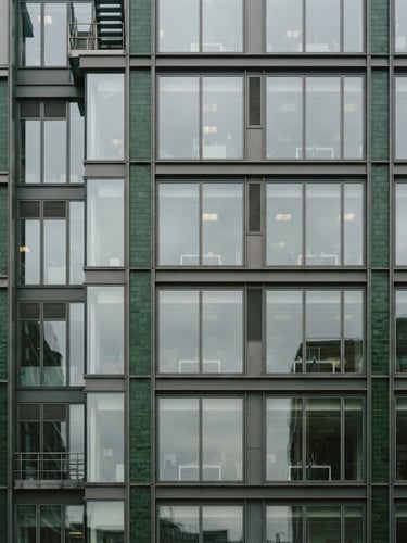 Architectural crop of a modern office building facade in Fitzrovia, London, overcast daylight, crisp lines, deep green accents, 35mm editorial film photography.