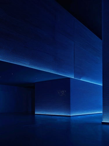Sleek high-contrast technology photography, extreme wide-angle architectural shot of a minimalist London office interior, sharp cool blue studio lighting, deep navy shadows, high-density lines
