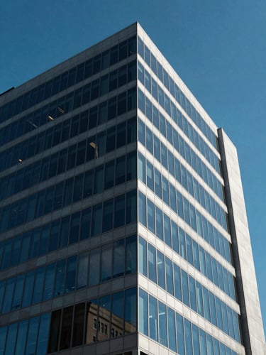 Bright, high-contrast architectural crop shot of a modern corporate office building in Delaware, sharp geometric lines, deep blue sky reflecting off glass panels.