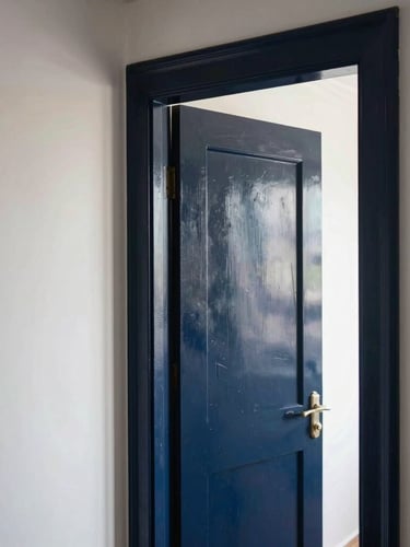 Crisp architectural view of a Dutch residential interior hallway, razor-sharp paint lines on a deep navy door frame against a chalk-white wall, soft morning daylight.