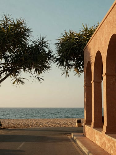 A peaceful coastal road leading toward the Tajpur sea beach, framed by Casuarina trees under warm golden-hour hazy sunlight, architectural detail