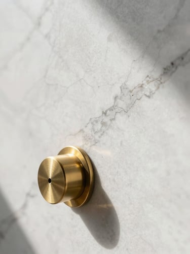 Tight abstract detail shot of premium white marble veins and brushed brass fixtures in indirect morning light